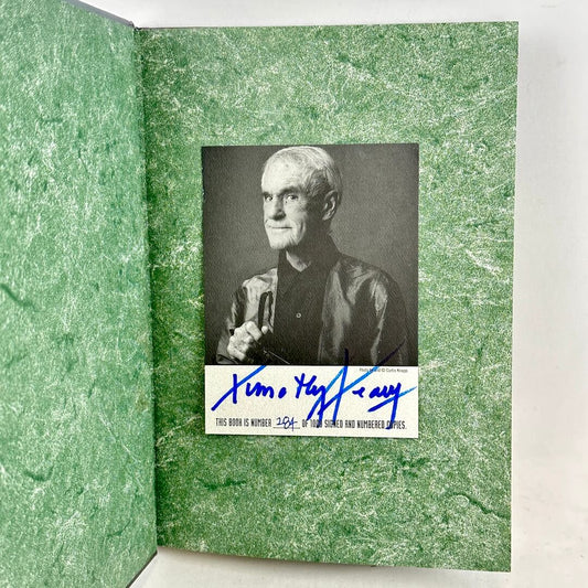 Green textured book with a black and white portrait and signature on a white background
