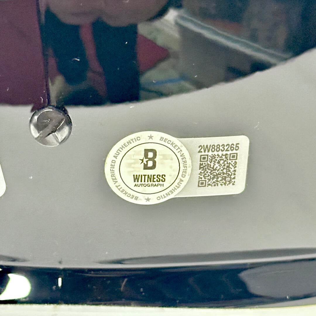 Close-up of a 'Witness Autograph' label on back of helmet.