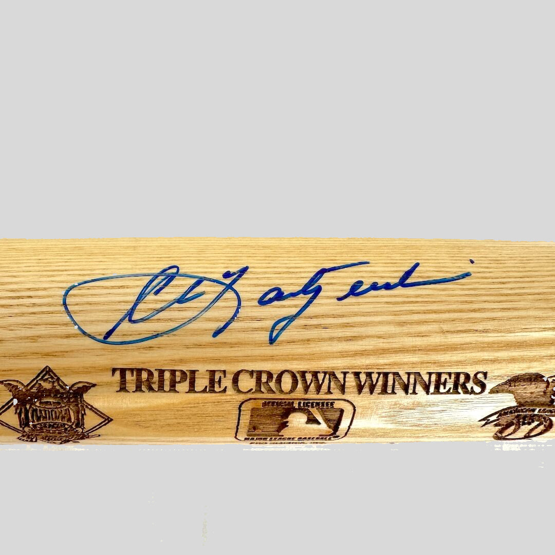 Wooden baseball bat with signature and 'Triple Crown Winners' text on a white background
