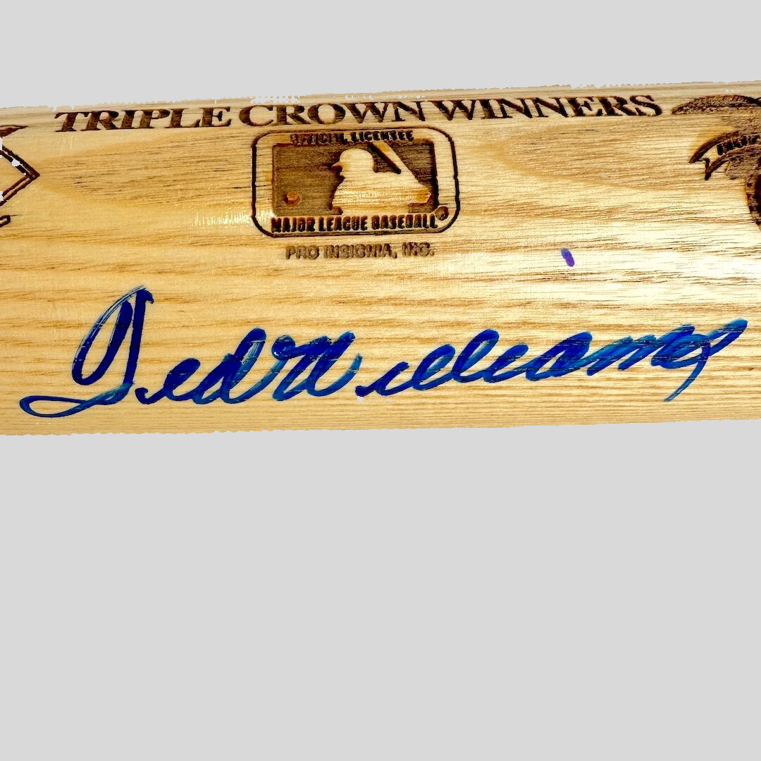 Wooden baseball bat with 'Triple Crown Winners' inscription and signature on a white background
