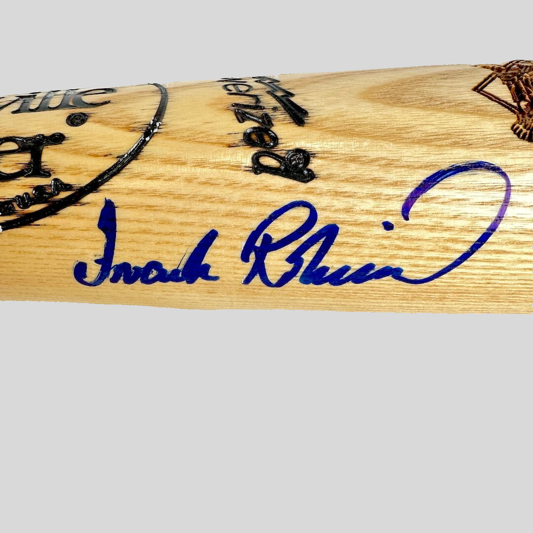 Wooden bat with engraved text and a signature on a white background