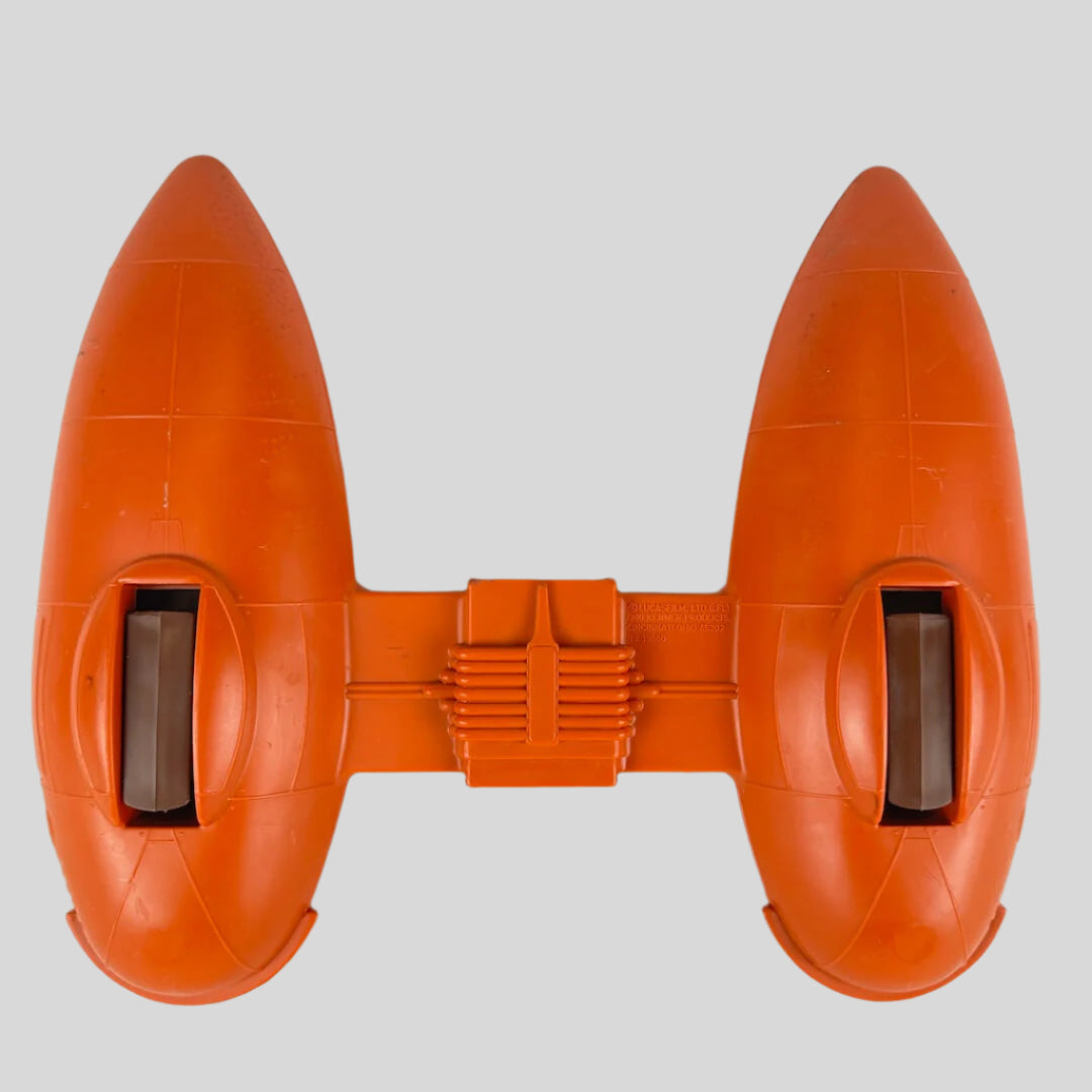 Orange toy spaceship with two compartments attached between them against gray background.