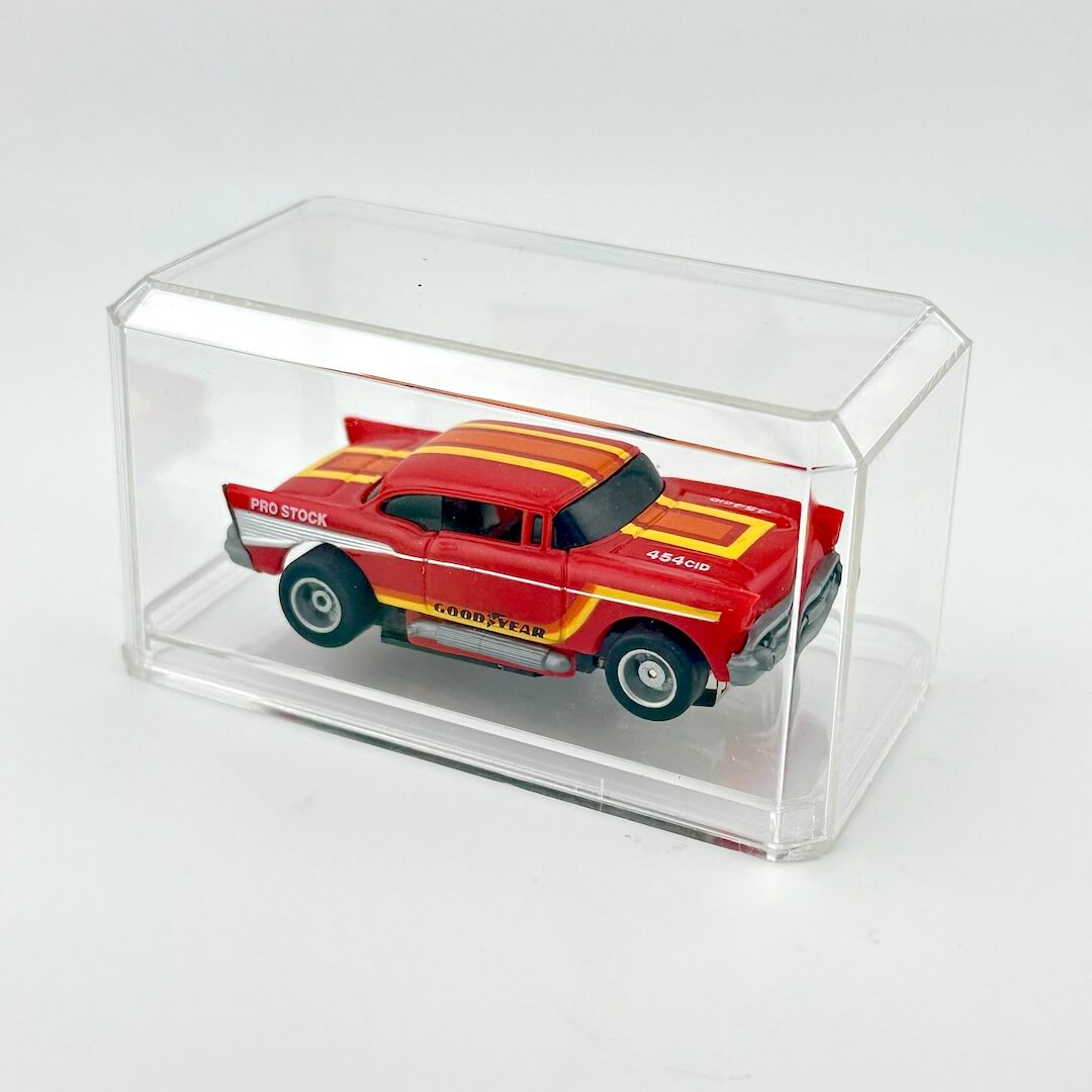 Red and yellow die-cast car in a clear display case on a white background