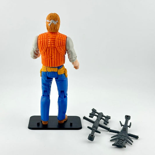 Action figure rin blue pants and orange vest with two accessories against white background.