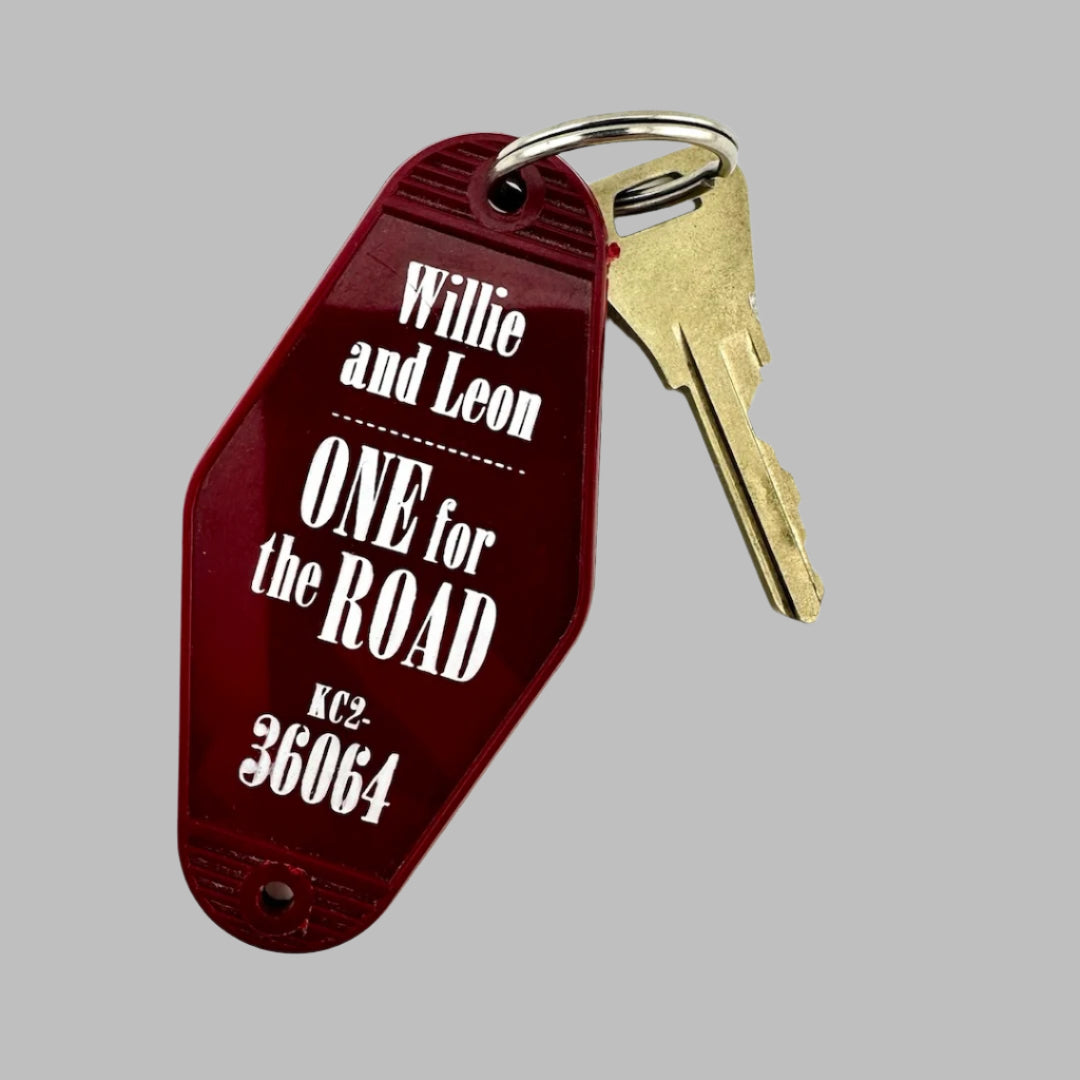 Red, flat, diamond-shaped keychain with white text, silver key ring, gold key "Weiser Wick" etched into it.