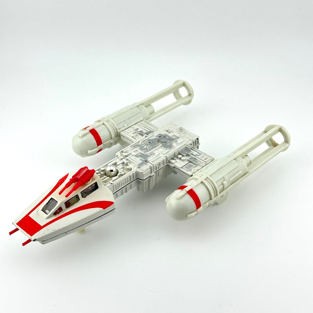 Toy model of a spaceship with red accents on a white background