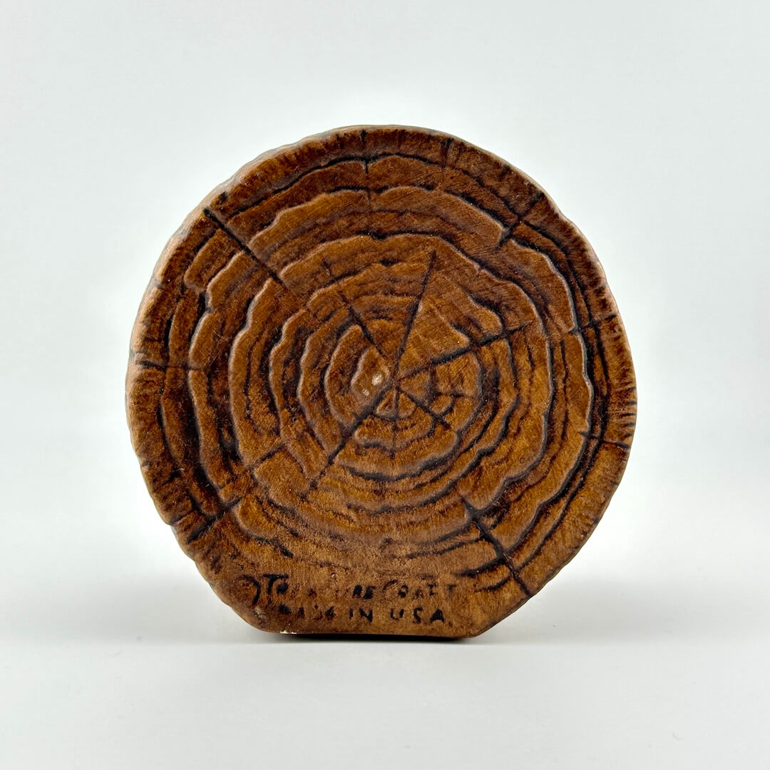 Ceramic bank made to look like wooden cross section. Copyright info along bottom.