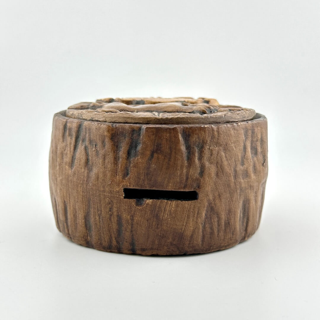 Top of coin bank made to look like wooden cross section.