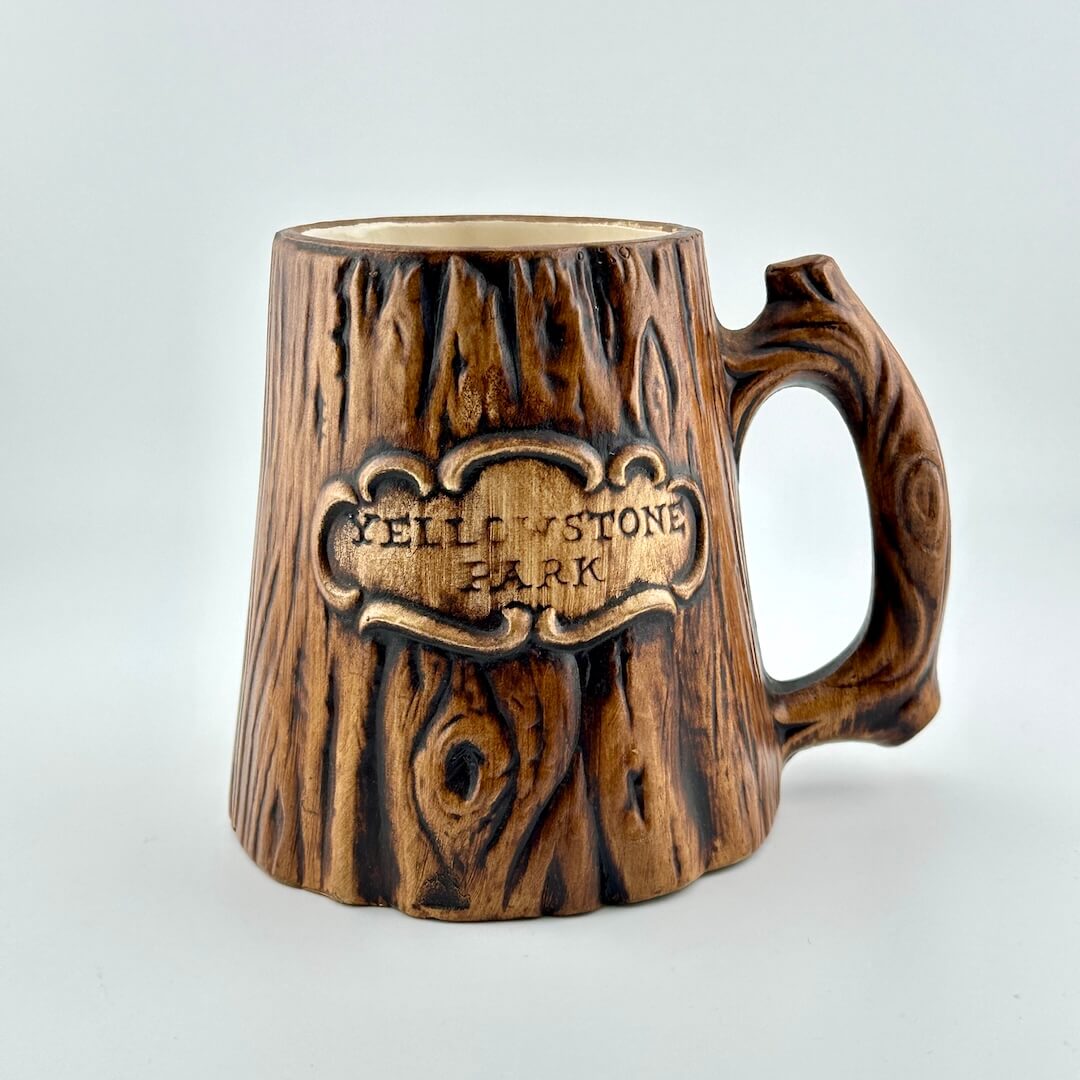 Wooden-textured mug with 'Yellowstone Park' engraving on a light gray background