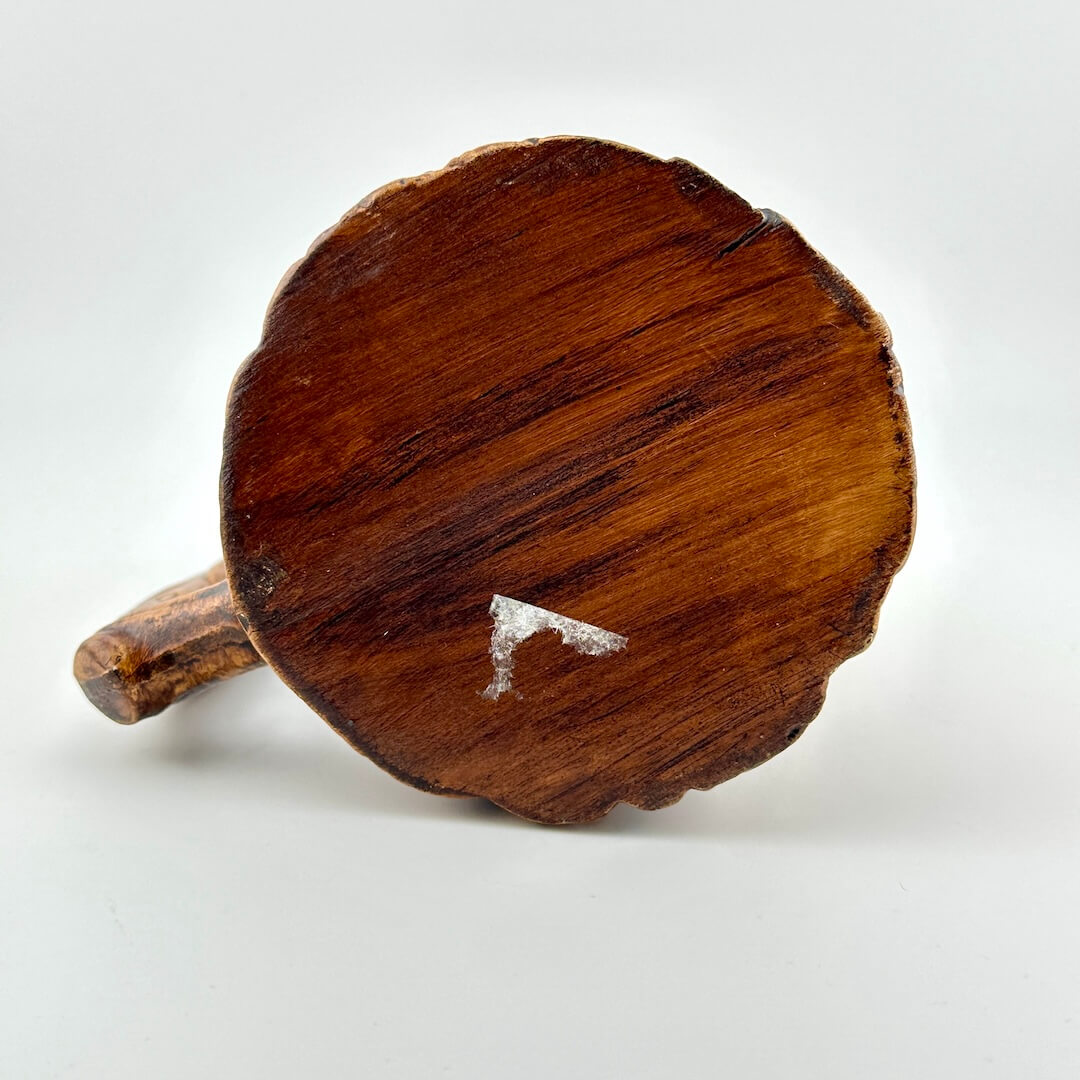 Bottom of wooden-style mug with remnant of price tag still visible.