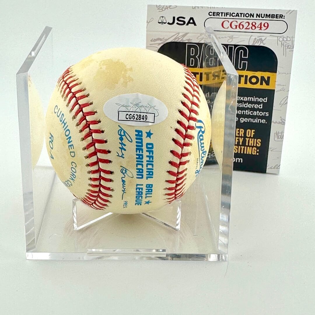 Baseball in a clear display case with a JSA certification behind it