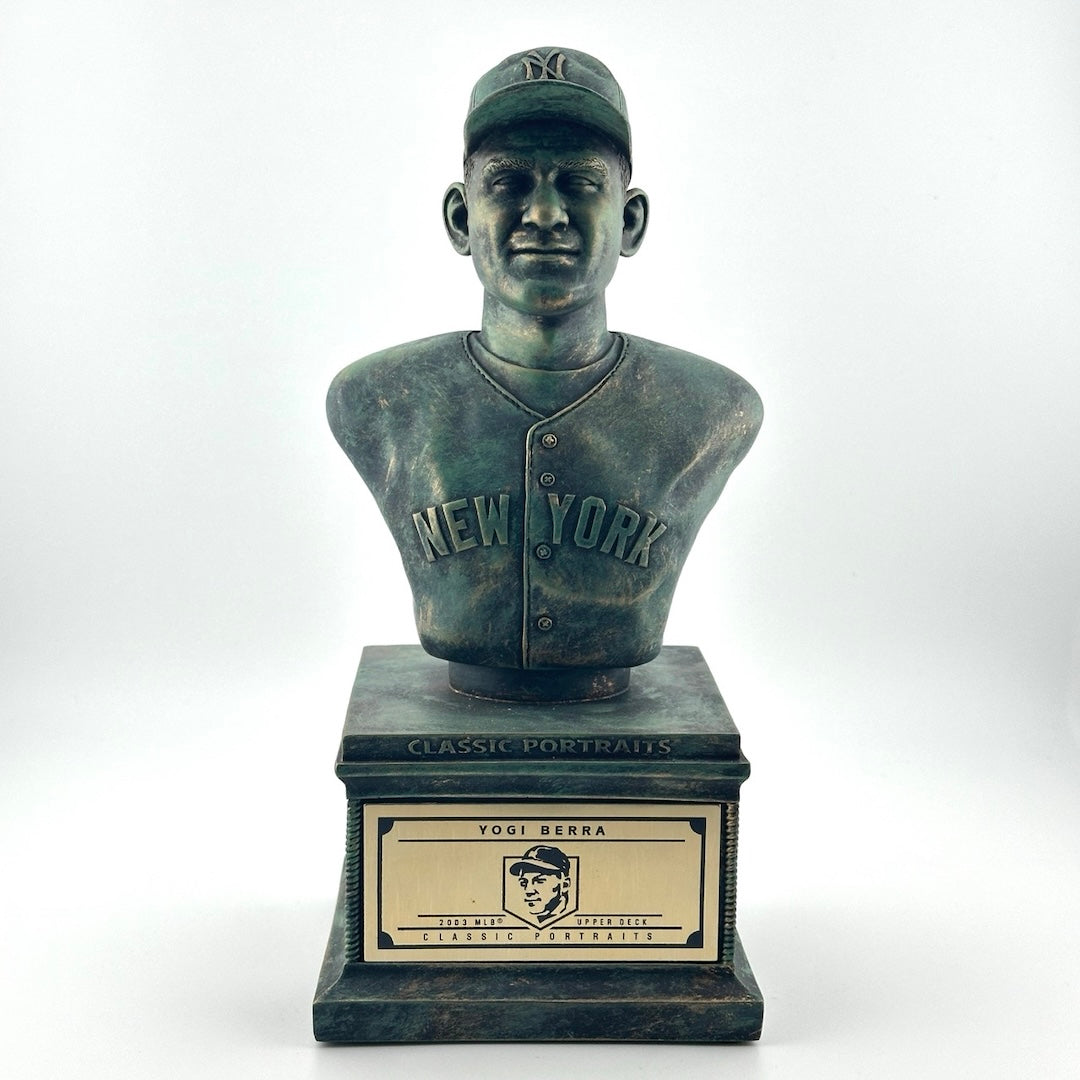 Bronze pedestal with bronze bust of Yogi Berra in NY Yankees uniform. Gold plaque on pedestal.