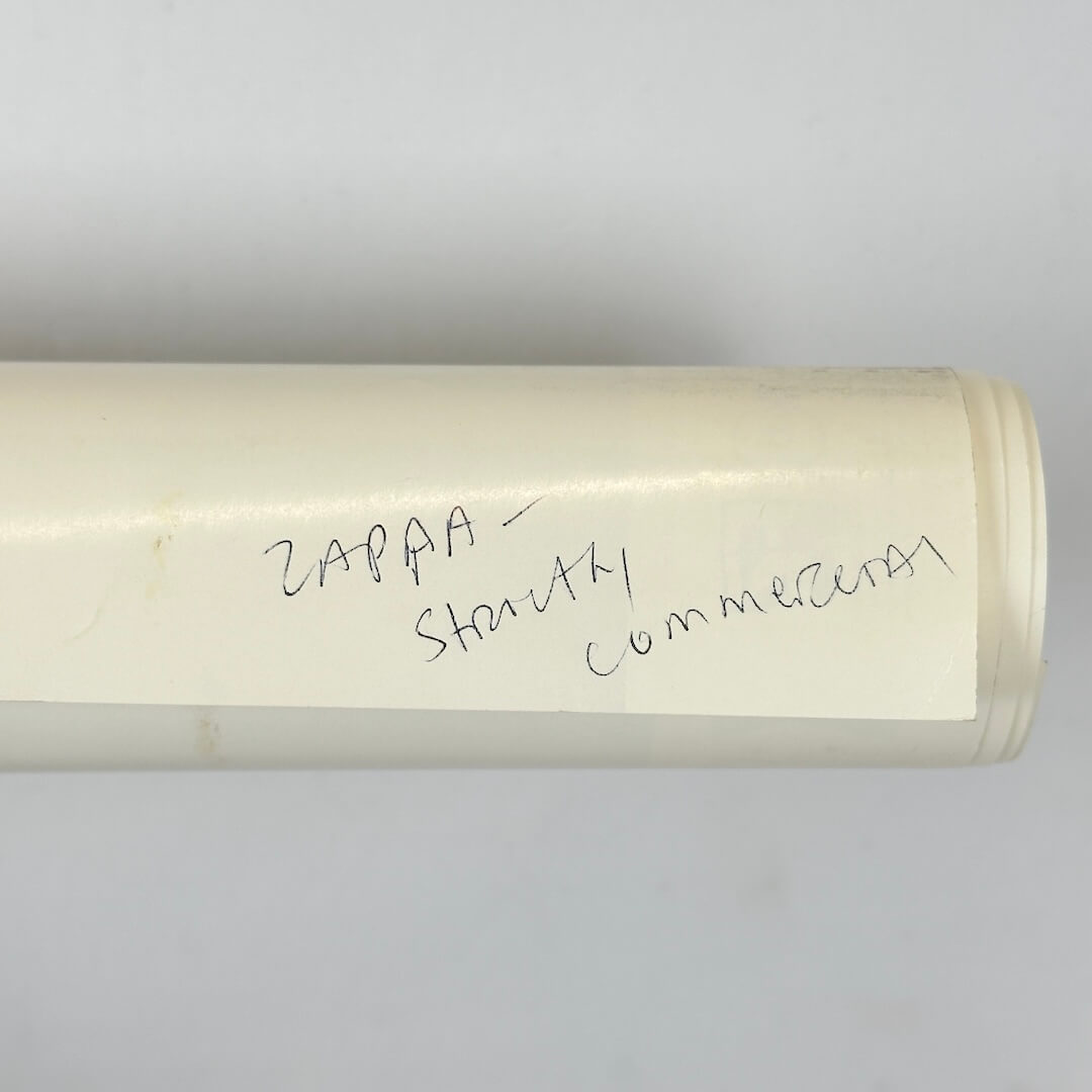 Rolled poster with artist name written in pen on backside.