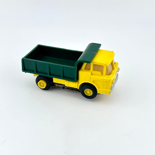 Toy dump truck with green bed and yellow body on a white background