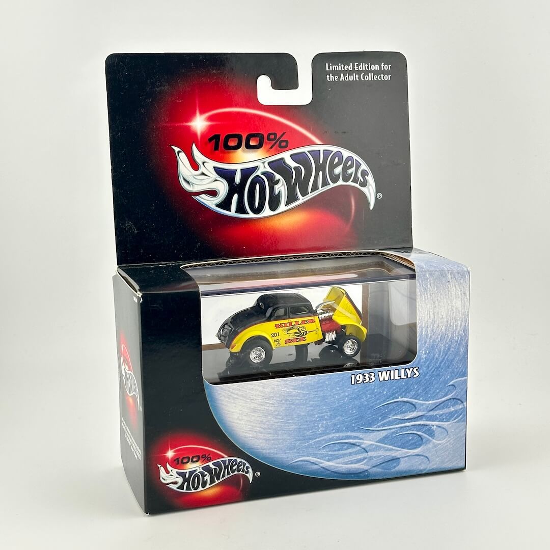 A Hot Wheels 1961 Willys diecast toy car in its original packaging, featuring a black and yellow car.