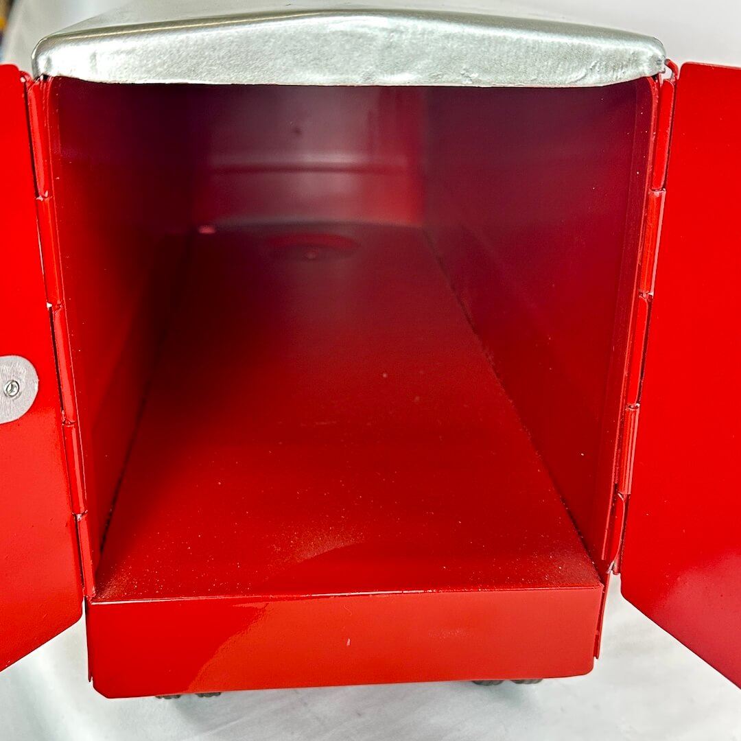 Interior of red toy transport trailer against white background.