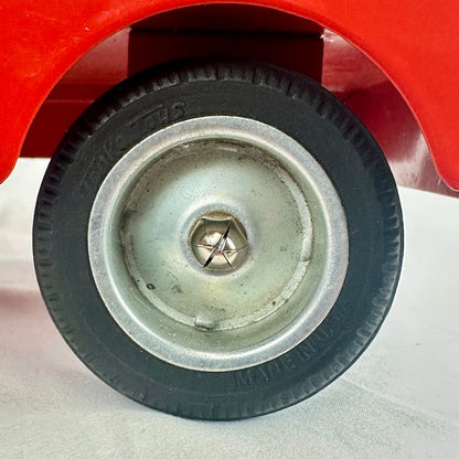 Close-up of a wheel with a red vehicle in the background