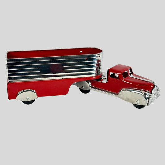 Red toy truck with a silver trailer on a white background