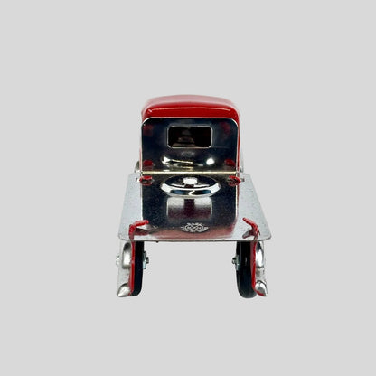 Model of a vintage truck with a red top and silver body on a white background