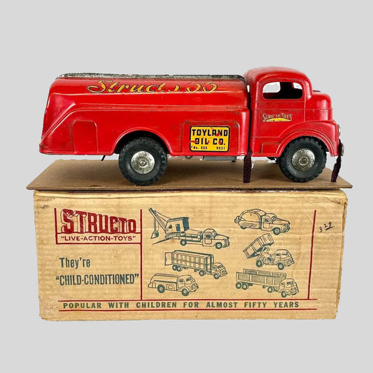 Red toy truck on top of its original box with branding and text.