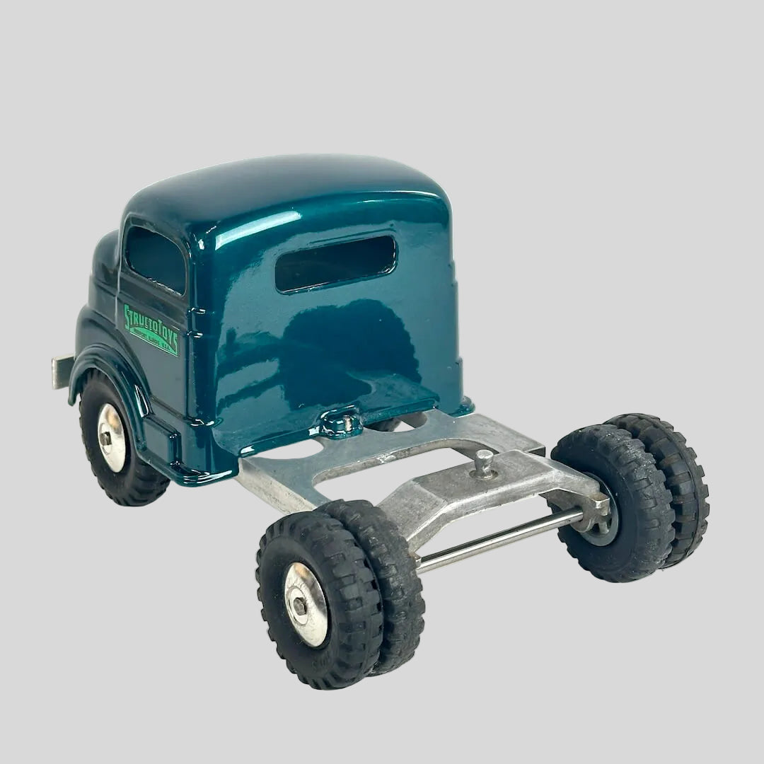 Model truck with a teal body and metal chassis on a white background