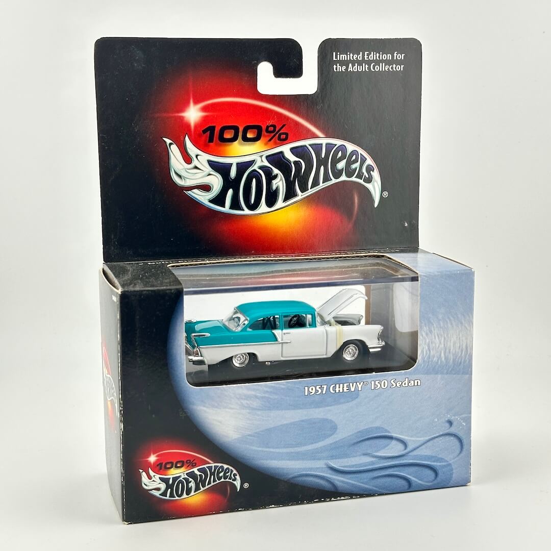 Teal and white 1957 Chevy 150 Sedan diecast car in retail packaging with Hot Wheels branding and window to show car. 