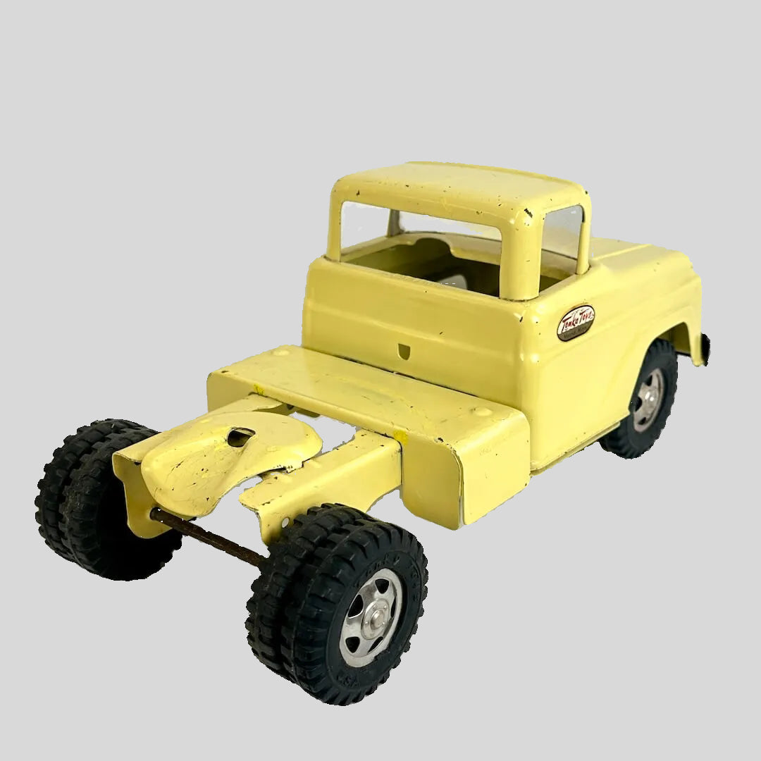 Yellow toy truck with large wheels on a white background
