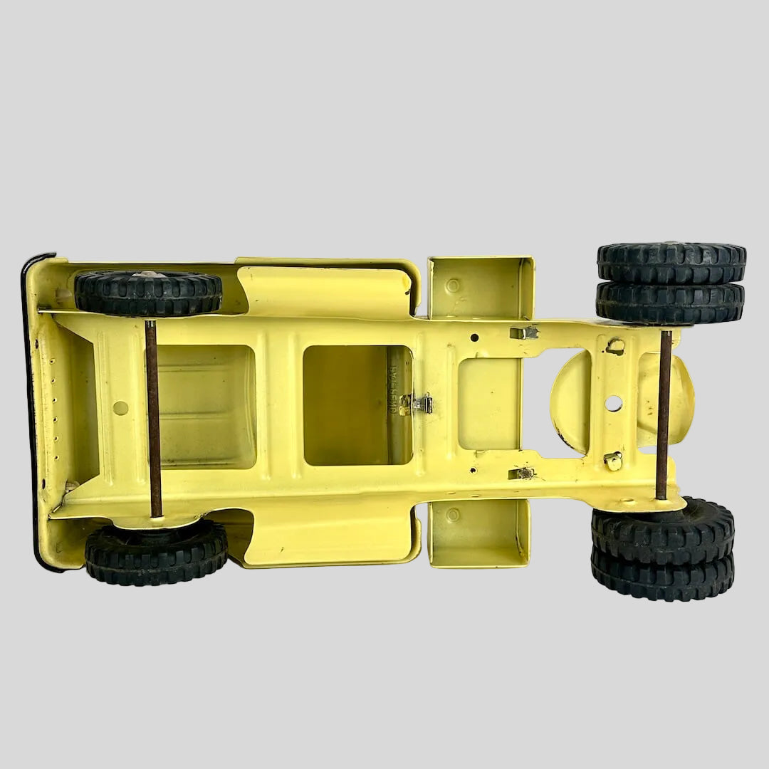 Yellow toy truck chassis with black wheels on a white background