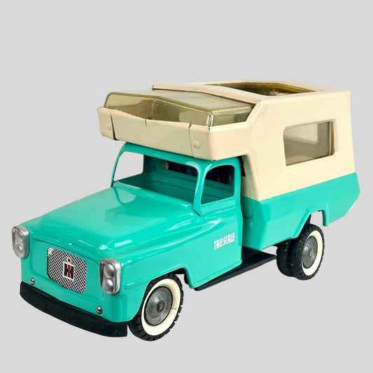 Model of a turquoise truck with beige camper top on a white background
