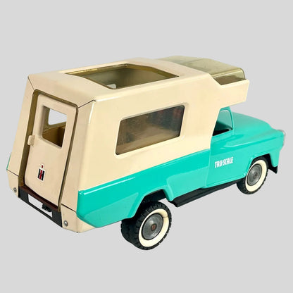 Model of a vintage truck with beige roof and turquoise body on a light gray background