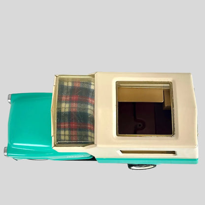 Top view of turquoise truck with beige camper against gray background. 