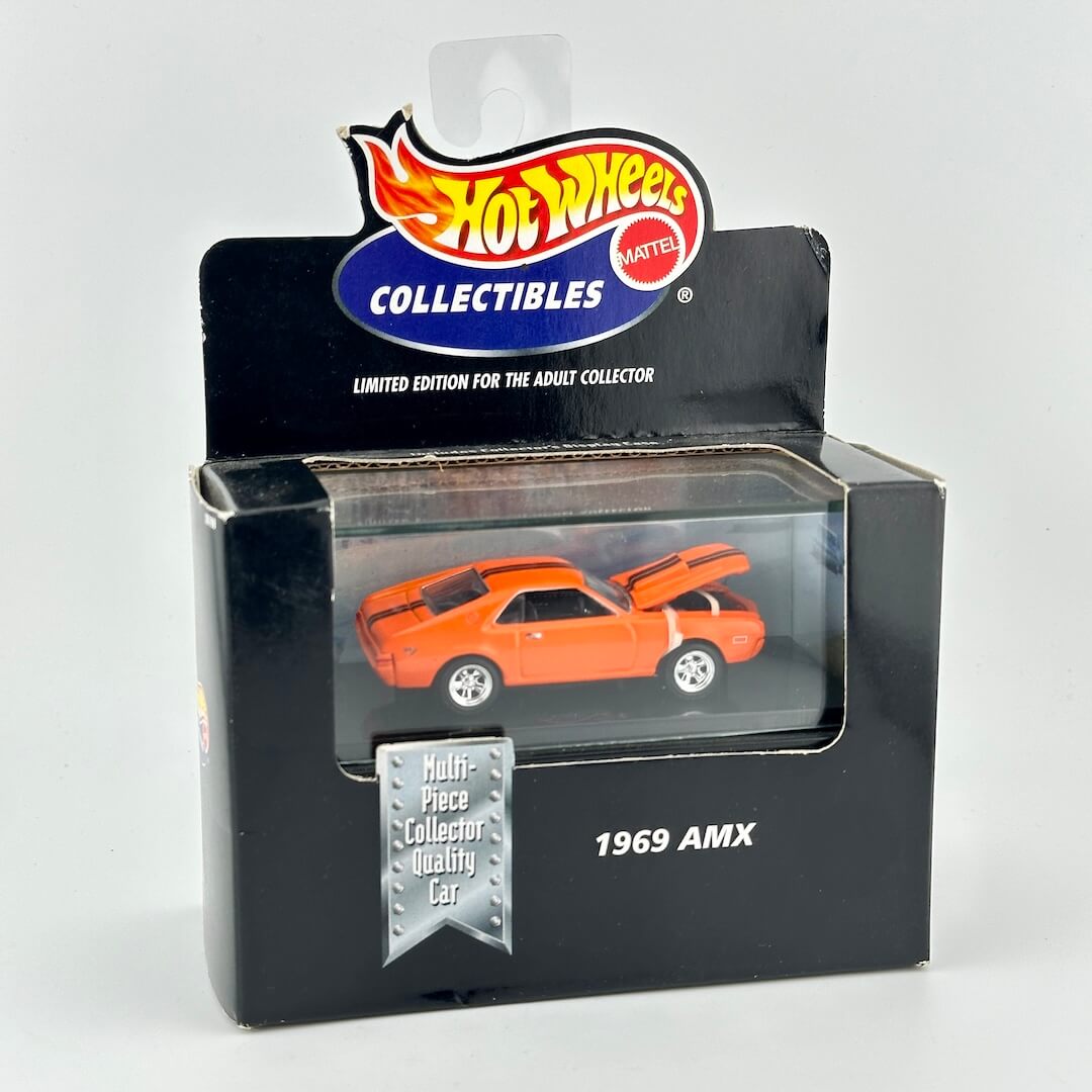Hot Wheels Collectibles 1969 AMX diecast toy car in its original packaging, featuring an orange car with black racing stripes.