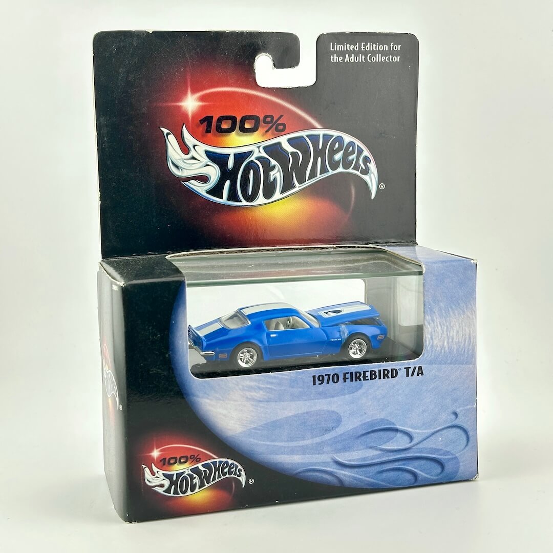 A 1970 Firebird T/A die-cast toy car in its original Hot Wheels packaging, featuring a blue car. 