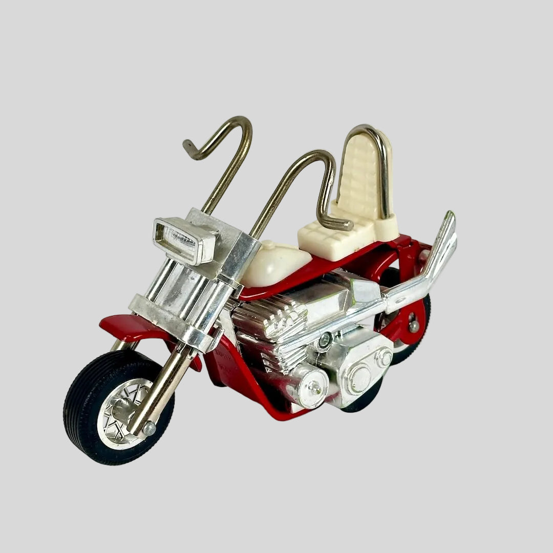 Model motorcycle with red body, silver engine, and beige seat on a white background