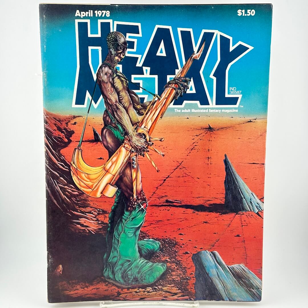 Magazine cover with stylized man holding futuristic weapon on barren landscape under text, 'heavy metal'