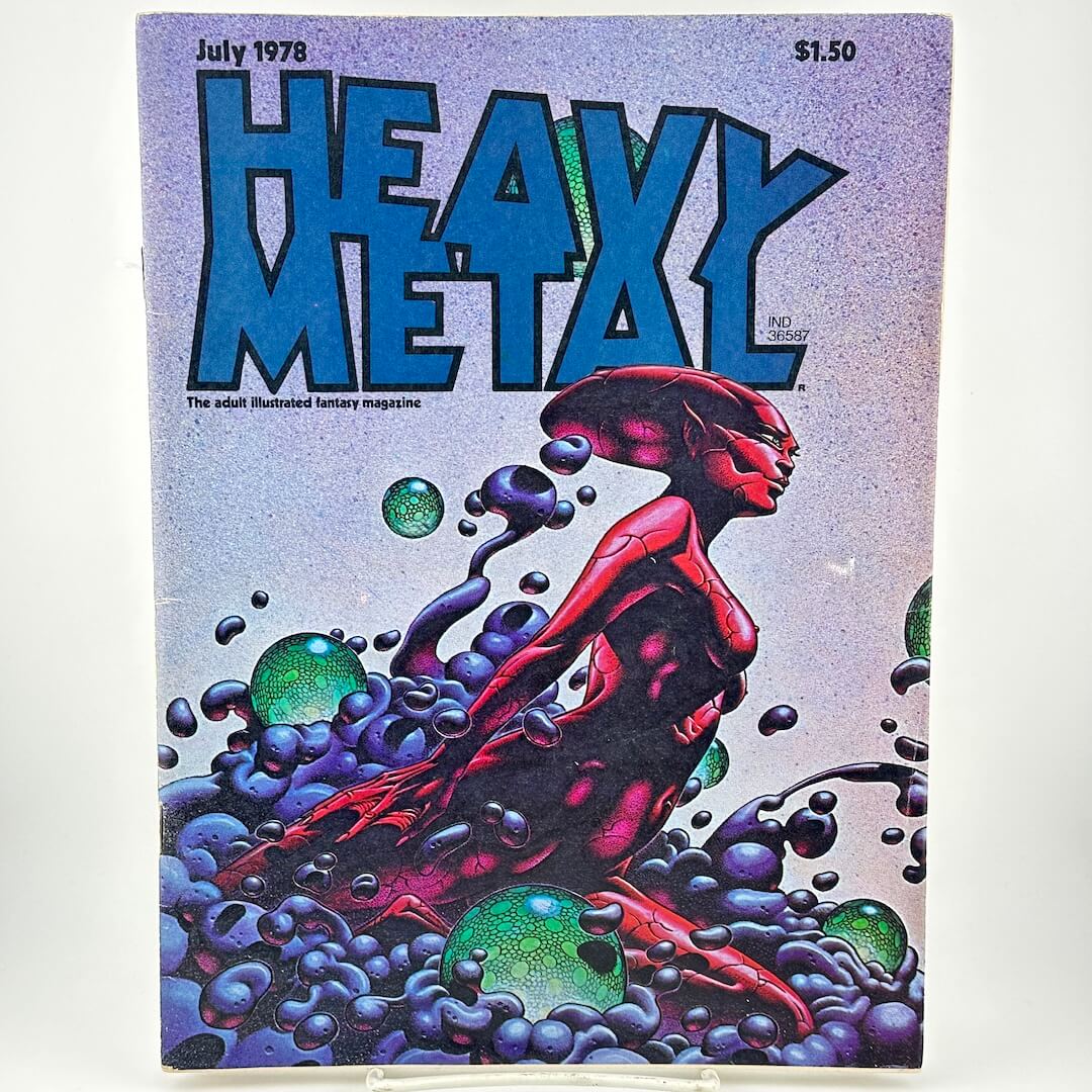 Magazine cover with alien woman emerging from blue and green liquid under text, "heavy metal"