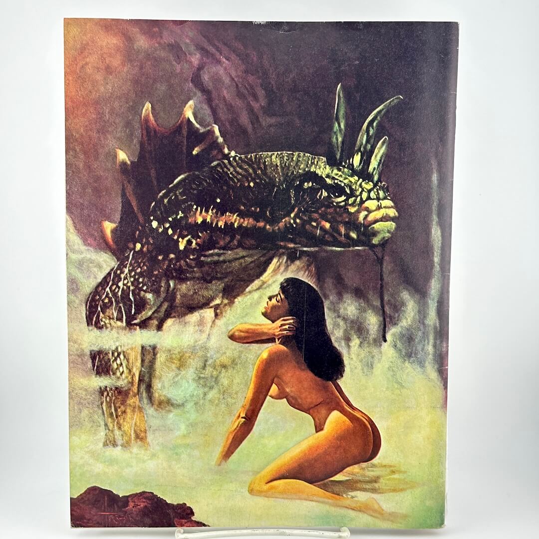 Back cover of magazine with naked woman in front of lizard creature. 