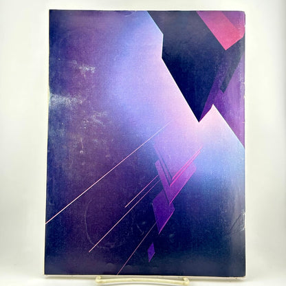 Back cover of magazine with abstract shapes in purple hues. 