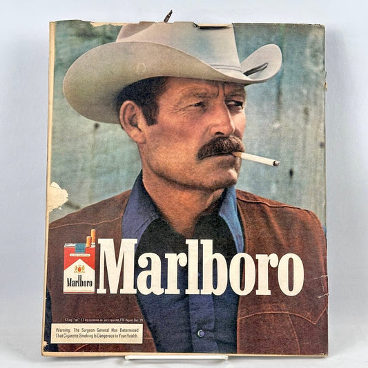 Vintage Marlboro cigarette ad featuring a portrait of a cowboy with a mustache smoking a cigarette.
