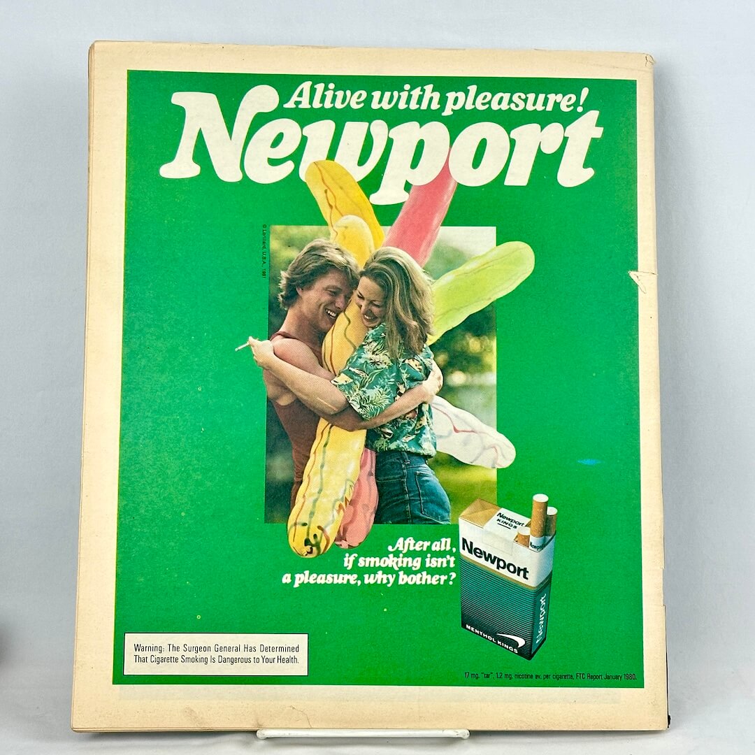 Back cover of magazine with ad for Newport cigarettes with green border around picture of two people laughing. 