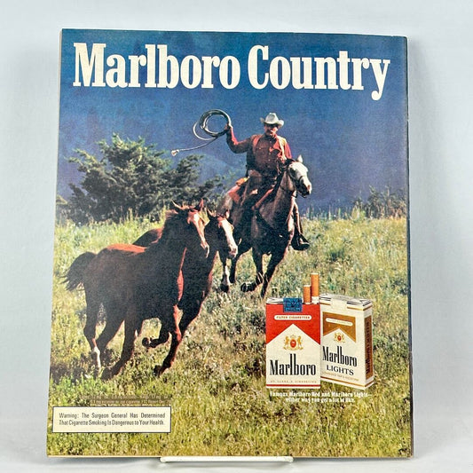 Back cover of magazine with vintage Marlboro ad featuring cowboy and wild horses. 