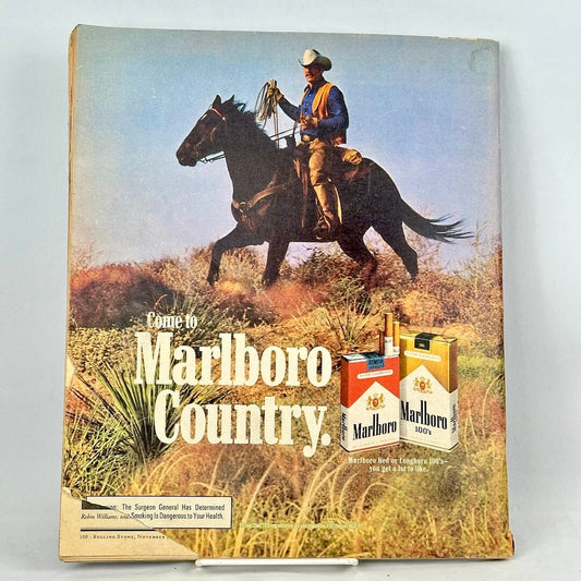 A vintage Marlboro cigarette ad on back cover featuring a cowboy riding a dark horse across a grassy landscape.
