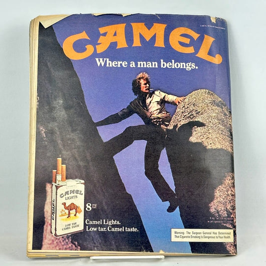 Vintage Camel cigarette ad on back cover of magazine featuring the slogan 'Where a man belongs.' with a man climbing a rock.
