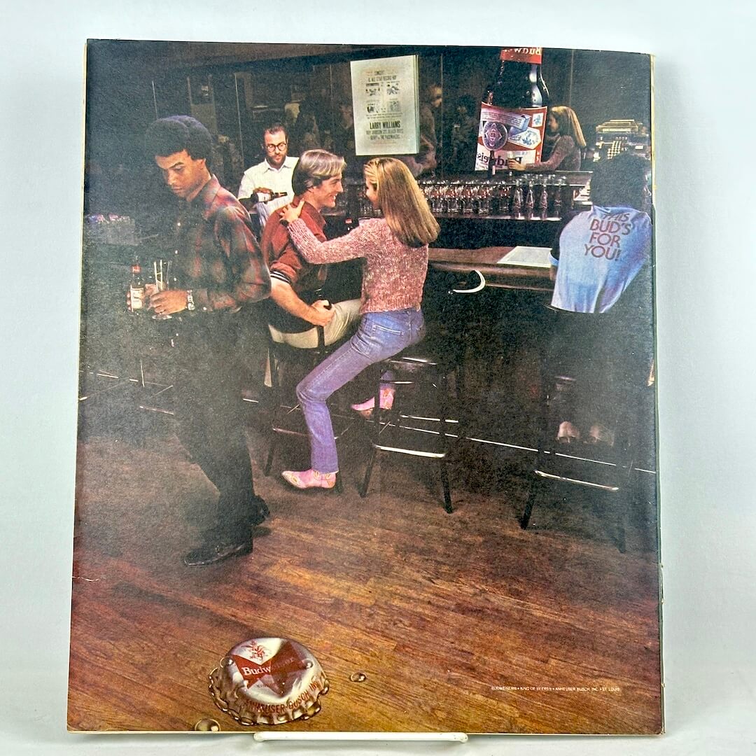 Back cover of magazine with full page Budweiser ad featuring image of bar scene.