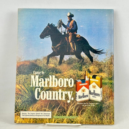Back cover of magazine with full page Marlboro ad featuring mounted cowboy riding through field. 