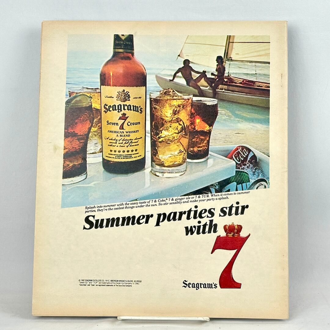 Back cover of magazine featuring full page ad for Seagram's 7 liquor with image of drinks on table on boat.