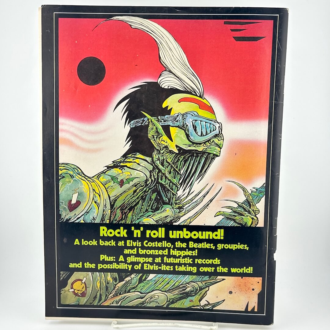 Back cover of magazine with monster/alien-like creature playing guitar. 