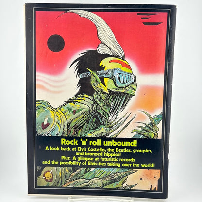 Back cover of magazine with monster/alien-like creature playing guitar. 