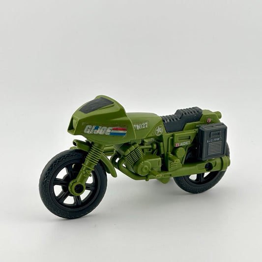 Army green motorcycle with grey carry cases on either side & grey seat, and has G.I. Joe & American flag sticker decals. 