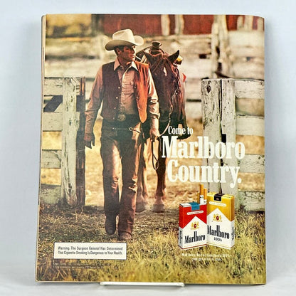 Back cover of magazine with full page ad for Marlboro cigarettes featuring a cowboy leading a horse through fence. 